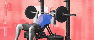 man bench presses heavy weight at gym